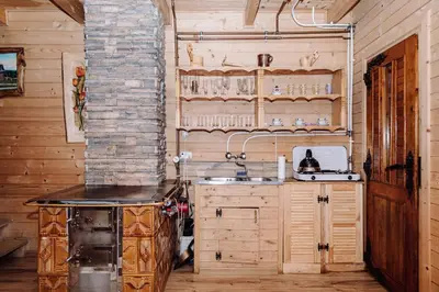 a kitchen with wooden cabinets and a sink in a room at Domek na uboczu in Klikuszowa