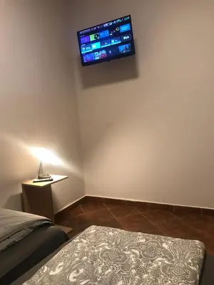 a bedroom with a bed and a tv on the wall at Piwnica in Miechów