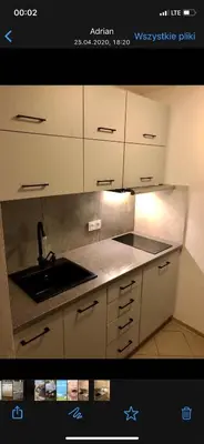 a kitchen with white cabinets and a sink at Piwnica in Miechów