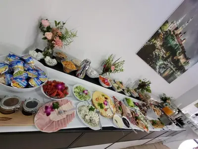 a buffet with plates of food on a table at Aparthotel Lumen in Kraków