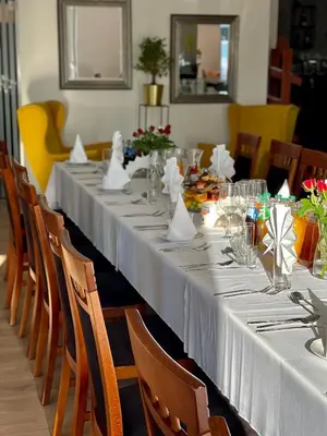a long table with white table cloths on it at Aparthotel Lumen in Kraków