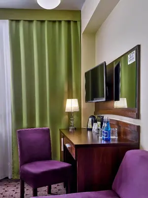 a hotel room with a desk and two chairs at Aparthotel Lumen in Kraków