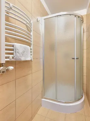 a shower with a glass door in a bathroom at Aparthotel Lumen in Kraków