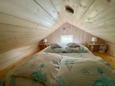 a bedroom with a large bed in a wooden room at Brzozowy Gaj in Bachowice