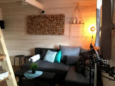 a living room with a couch and wooden walls at Brzozowy Gaj in Bachowice