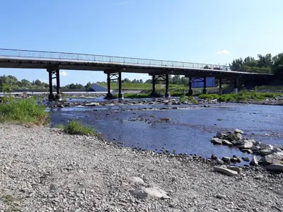 a bridge over a river with rocks in the water at Agroturystyka u Krzysztofa ZATOR ,ENERGYLANDIA , NOCLEGI in Graboszyce