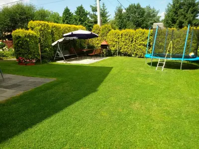 a yard with a playground and an umbrella and grass at Agroturystyka u Krzysztofa ZATOR ,ENERGYLANDIA , NOCLEGI in Graboszyce