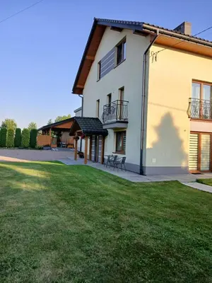 a large white house with a lawn in front of it at Agroturystyka u Krzysztofa ZATOR ,ENERGYLANDIA , NOCLEGI in Graboszyce