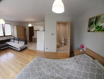 a bedroom with a bed and a living room with a couch at Agroturystyka u Krzysztofa ZATOR ,ENERGYLANDIA , NOCLEGI in Graboszyce