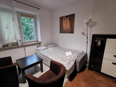 a small bedroom with a bed and a table and chairs at Krakow Centrum Gurgacza Apartments in Kraków