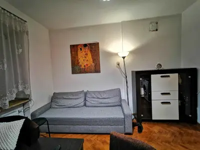 a living room with a couch and a painting on the wall at Krakow Centrum Gurgacza Apartments in Kraków
