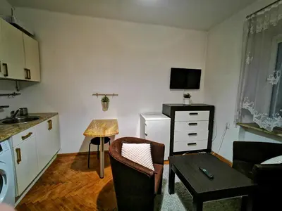 a small living room with a kitchen and a table at Krakow Centrum Gurgacza Apartments in Kraków