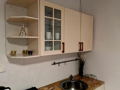 a kitchen with white cabinets and a sink at Krakow Centrum Gurgacza Apartments in Kraków