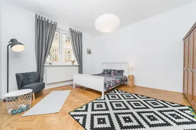 a living room with a bed and a chair at Two separate bedrooms,10 min walk to the city center by Homeclick in Kraków