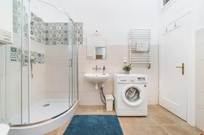 a bathroom with a washing machine and a sink at Two separate bedrooms,10 min walk to the city center by Homeclick in Kraków