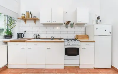 a white kitchen with white cabinets and appliances at Two separate bedrooms,10 min walk to the city center by Homeclick in Kraków