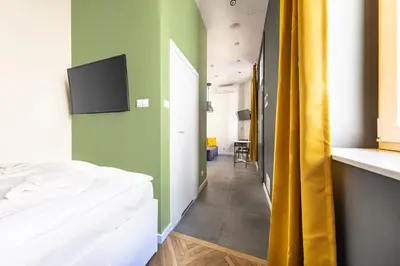 a bedroom with a bed and a tv on the wall at MioMio Apartments in Kraków
