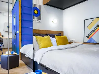 a bedroom with a bed with blue and yellow pillows at MioMio Apartments in Kraków