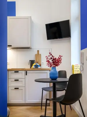 a kitchen with a table with a vase of flowers on it at MioMio Apartments in Kraków