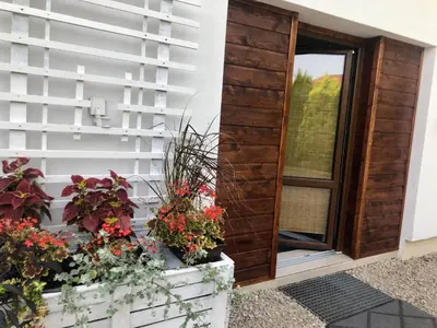 a door to a house with flowers in a box at Apartament STUDIO i Apartament ZADOMEK Spytkowice koło ZATORA in Spytkowice