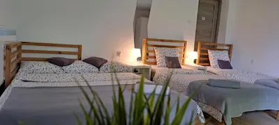 a bedroom with three beds with pillows at Apartament Na Szkolnej in Zator