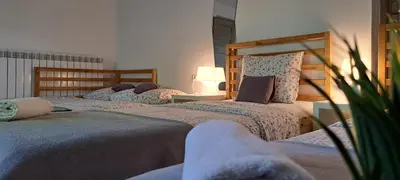 a bedroom with two beds and a table with a lamp at Apartament Na Szkolnej in Zator