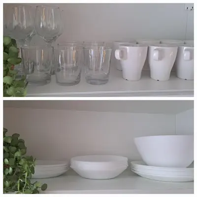 a shelf with glasses and plates and bowls on it at Apartament Na Szkolnej in Zator