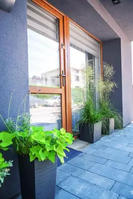 a door with pots of plants in front of a building at Apartament Na Szkolnej in Zator