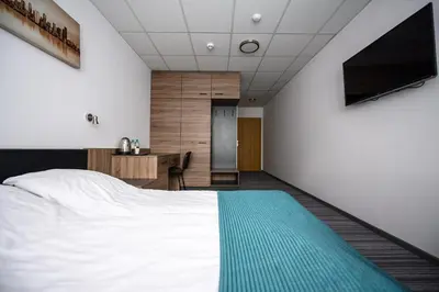 a bedroom with a bed and a desk and a television at Hut Pus Spółka Akcyjna in Kraków
