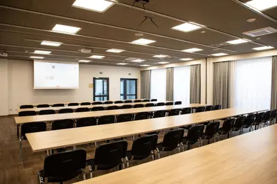 an empty lecture hall with a large wooden table and chairs at Hut Pus Spółka Akcyjna in Kraków