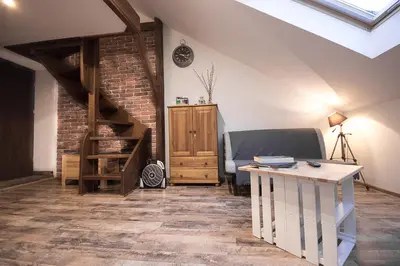 a living room with a couch and a table at Apartamenty Za Winklem in Kraków
