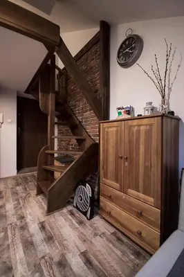 a loft conversion with a staircase and a wooden cabinet at Apartamenty Za Winklem in Kraków