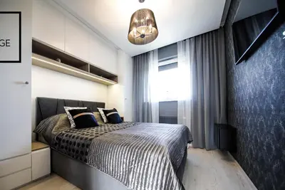a bedroom with a large bed and a light at Luksusowy apartament z tarasem in Kraków