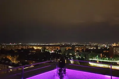 a view of a city at night with purple lights at Luksusowy apartament z tarasem in Kraków