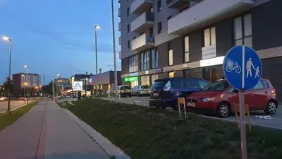 a street with cars parked in front of a building at Luksusowy apartament z tarasem in Kraków
