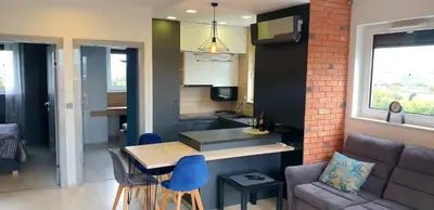 a kitchen and a living room with a table and a couch at Luksusowy apartament z tarasem in Kraków