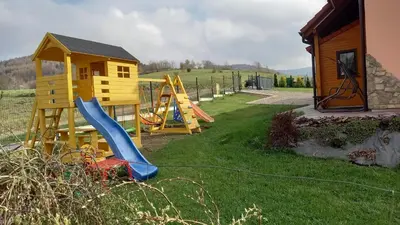 a playground with a slide and a house at Ranczo pod Klimoską in Rzyki