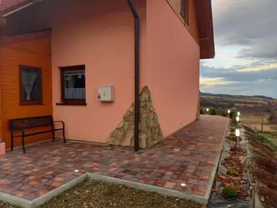 a patio outside of a building with a rock wall at Ranczo pod Klimoską in Rzyki
