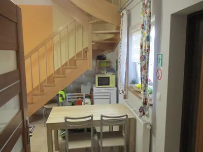 a kitchen with a table and a staircase in a room at Ranczo pod Klimoską in Rzyki