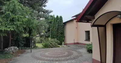 a garden with a stone path in front of a house at Dom nad Wisłą in Czernichów