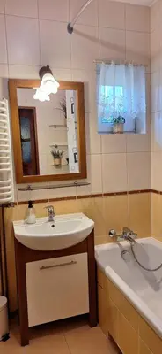 a bathroom with a sink and a tub and a mirror at Dom nad Wisłą in Czernichów