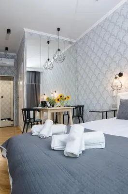 a bedroom with two beds with white pillows and a table at Cracovia Wawel Apartments in Kraków