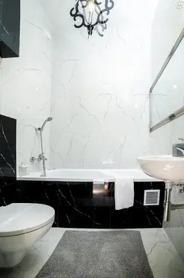 a bathroom with a white tub and a sink at Cracovia Wawel Apartments in Kraków