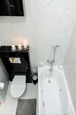 a bathroom with a white tub and a toilet at Cracovia Wawel Apartments in Kraków