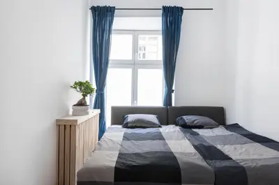 a bedroom with a bed with blue curtains and a window at Tomasza 20 Apartment 140m2 in Kraków