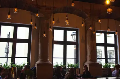 people sitting at tables in a restaurant with windows at Tomasza 20 Apartment 140m2 in Kraków