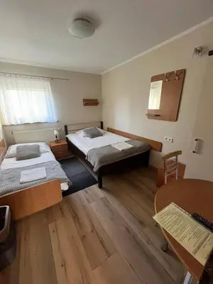 a room with two beds and a table at Dom Kolping in Kraków