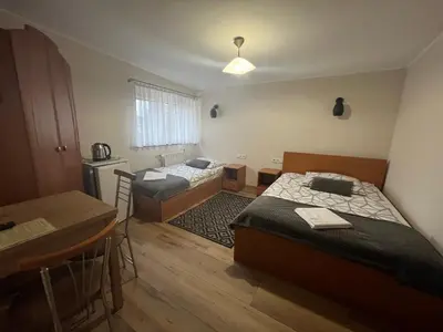 a small room with two beds and a table and a table at Dom Kolping in Kraków