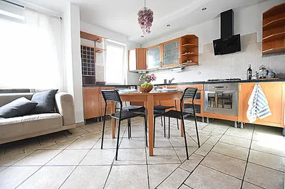 a kitchen with a table and chairs and a couch at Mhost Bronowice in Kraków