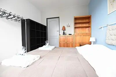 a bedroom with a large bed and a wooden closet at Mhost Bronowice in Kraków